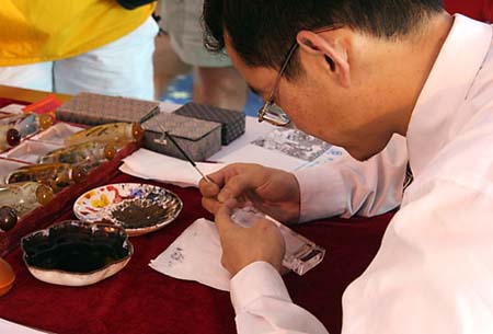 07 Artist paints inside bottle